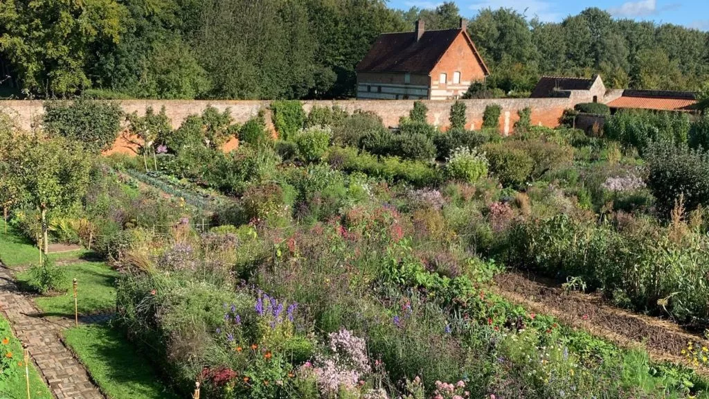 Jardin potager fleuri du Château de Miromesnil avec massifs cultivés et mur en briques anciennes